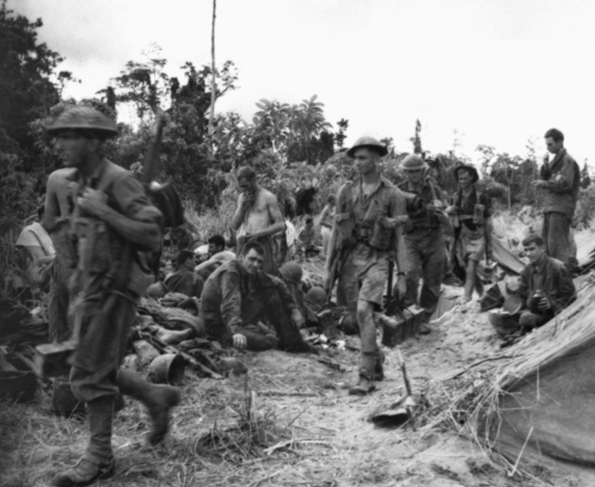 Australians of the 2/12th Battalion move past a group of Americans. 